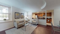 This single-floor residence combines thoughtful design with practical features throughout its well-organized layout. The living room serves as a welcoming centerpiece, showcasing rich dark hardwood flooring, neutral walls, and multiple windows that invite natural light. A distinctive tray ceiling adds architectural interest overhead, while the open layout connects seamlessly to the dining area, which benefits from two large windows offering views of the surrounding greenery.

The kitchen is efficiently designed with warm wood cabinetry, dark granite countertops, tile flooring, and a full suite of stainless steel appliances including a refrigerator, electric range, microwave, and dishwasher. A breakfast bar with dark countertop opens toward the living area, enhancing the open-concept flow. A louvered closet door provides additional pantry or storage access within the kitchen.

The bedroom is carpeted and serene, featuring a walk-in closet with built-in shelving and a window that brings in natural light. The full bathroom includes a wood-toned vanity with dark granite countertop, a tub-shower combination with tile surround, and tile flooring, offering a clean and functional design throughout.