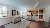 This single-floor residence combines thoughtful design with practical features throughout its well-organized layout. The living room serves as a welcoming centerpiece, showcasing rich dark hardwood flooring, neutral walls, and multiple windows that invite natural light. A distinctive tray ceiling adds architectural interest overhead, while the open layout connects seamlessly to the dining area, which benefits from two large windows offering views of the surrounding greenery.

The kitchen is efficiently designed with warm wood cabinetry, dark granite countertops, tile flooring, and a full suite of stainless steel appliances including a refrigerator, electric range, microwave, and dishwasher. A breakfast bar with dark countertop opens toward the living area, enhancing the open-concept flow. A louvered closet door provides additional pantry or storage access within the kitchen.

The bedroom is carpeted and serene, featuring a walk-in closet with built-in shelving and a window that brings in natural light. The full bathroom includes a wood-toned vanity with dark granite countertop, a tub-shower combination with tile surround, and tile flooring, offering a clean and functional design throughout.