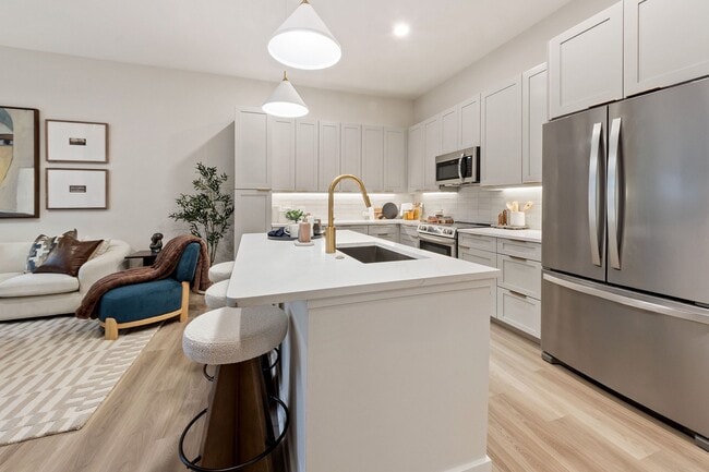 Upscale living starts in the kitchen: premium quartz countertops, stainless steel appliances, and designer lighting creates a space that is both stylish and functional - The Residence Peninsula Apartments