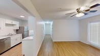 Located at 103 Hillcrest Ct in New Market, Alabama, this single-floor, two-bedroom, two-bathroom home offers a clean and functional layout designed for comfortable everyday living. Light wood-style flooring runs throughout the entire space, creating a cohesive and bright atmosphere across every room.

The open living area is anchored by a ceiling fan and flows seamlessly into the combined dining room and kitchen. The galley-style kitchen is well-appointed with white shaker cabinetry featuring brushed nickel hardware, light marble-style countertops, a double-basin sink, and stainless steel appliances including a refrigerator, electric range, and over-the-range microwave.

The spacious primary bedroom offers generous room with ample natural light and direct access to a closet. The second bedroom also features hardwood-style flooring and a built-in closet with wire shelving. An additional walk-in closet provides extra storage capacity. Both bathrooms are finished consistently with white vanities, tub-shower combinations, brushed nickel grab bars, and matching flooring.

A central hallway connects all rooms efficiently, and the layout benefits from a dedicated walk-in closet with wire rack shelving. The home's neutral white walls and consistent finishes throughout create a bright, move-in-ready environment.