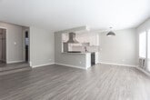 Located at 5525 N Avenue 56 in the vibrant Highland Park neighborhood of Los Angeles, this thoughtfully updated single-floor residence offers a clean, modern aesthetic throughout. The open-concept living area is anchored by warm wood-look flooring and neutral gray walls, creating a bright and cohesive atmosphere. Large windows and glass panel doors along one wall allow abundant natural light to pour in, while also providing a welcoming sense of openness.

The kitchen is a standout feature, designed with both style and functionality in mind. White shaker cabinetry pairs elegantly with a geometric tile backsplash and light quartz countertops. A peninsula with built-in cooktop serves as the kitchen's centerpiece, complemented by a stainless steel range hood, full-size refrigerator, and built-in microwave. Dark hexagonal floor tile in the kitchen adds a striking contrast to the rest of the space. A pendant light fixture bridges the kitchen and living area seamlessly.

The bedrooms are well-proportioned, featuring the same wood-look flooring, neutral walls, and windows that bring in natural light. One room includes a wall-mounted air conditioning unit for individualized climate control. The overall layout is practical and efficient, with a clean, move-in-ready condition throughout. This residence offers a well-balanced combination of updated design and everyday comfort.