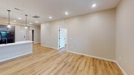 This 840 square foot residence, located at Foxglove ADA, offers a thoughtfully designed single-floor layout optimized for accessibility and modern living. The home comprises one bedroom, one bathroom, a combined kitchen and living room area, two hallways, and a dedicated laundry space. The primary bedroom, measuring 180 square feet, provides ample space and features a ceiling fan for comfort.

The open-concept living area is the heart of the home, showcasing a sleek electric fireplace that serves as a focal point. Beautiful hardwood flooring extends throughout, creating a cohesive and warm ambiance. The kitchen boasts modern gray cabinetry, contrasting nicely with white countertops and backsplash. Black appliances, including a refrigerator and range, complete the contemporary aesthetic.

The bathroom is designed with accessibility in mind, featuring grab bars, a spacious layout, and a floating vanity. The laundry room is equipped with a full-sized washer and dryer, ensuring convenience for daily tasks. Recessed lighting throughout the home provides even illumination, while windows allow natural light to flood the spaces.

ADA considerations are evident in the wide doorways, lever-style door handles, and overall spacious design that allows for easy maneuverability. The neutral color palette and clean lines contribute to a modern, inviting atmosphere, making this compact home both functional and stylish.