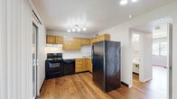 Located at 1832 Pueblo Pass in Evansville, Indiana, this two-story residence offers a straightforward and functional layout distributed across two levels. The main level entry opens to warm hardwood flooring that carries throughout, leading to a staircase connecting both floors. The kitchen is equipped with oak cabinetry providing ample storage, white countertops, a double-basin sink, and black appliances including a range, dishwasher, and refrigerator. Track lighting illuminates the kitchen workspace effectively.

The upper level features carpeted rooms that provide a softer, quieter environment. Multiple rooms on this level include windows fitted with blinds, allowing natural light while maintaining privacy. Notably, at least two rooms feature sliding glass doors with vertical blinds that open directly onto a balcony overlooking surrounding greenery, offering pleasant outdoor views.

Bathrooms include a full bath with a tub-shower combination, wood-toned vanity cabinetry, and white fixtures, as well as a half bath with hardwood flooring and built-in closet storage. Textured ceilings are present throughout, and neutral wall tones create a consistent, cohesive aesthetic across all rooms.