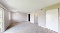 Located at 59 Port Ocall Dr in Indianapolis, Indiana, this single-floor, 3-bedroom, 1-bathroom home offers a practical and comfortable layout. The interior is finished in neutral gray tones throughout, with wall-to-wall carpeting across the living areas and bedrooms, contributing to a warm and cohesive aesthetic. Ceiling fans are present in multiple rooms, providing efficient air circulation.

The spacious primary bedroom is notably generous in size, featuring a ceiling fan, a large closet with bifold doors, and a sliding glass door that opens to the outdoors, allowing for natural light and exterior views. The additional bedrooms are well-proportioned, each with carpeted floors, neutral walls, and windows that bring in natural light — one features a dedicated closet space.

The kitchen is efficiently designed with rich dark-wood cabinetry, light speckled countertops, black appliances including a range and refrigerator, and ample upper and lower cabinet storage. The bathroom includes a full soaking tub with a shower, white subway-style tiling, and clean, functional fixtures.

A hallway connects the rooms and contributes to the home's straightforward, easy-to-navigate floor plan. The overall layout, as visible in the dollhouse view, is compact yet well-organized, making efficient use of every area within the home.