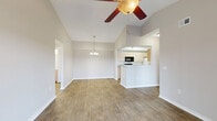 Located in Leesburg, Florida, this single-story home offers a practical and well-appointed layout across four bedrooms and two full bathrooms. The combined kitchen and living room area serves as the heart of the home, with the kitchen featuring light wood cabinetry, a double sink, a gas range, and wood-look plank flooring that extends through the hallway and living spaces. The living room is brightened by a ceiling fan and a sliding glass door that opens to an outdoor view, inviting natural light throughout.

Each of the four bedrooms is finished with soft carpeting, neutral-toned walls, and ceiling fans, creating a comfortable and consistent aesthetic. Windows with blinds provide natural light and neighborhood views, while closet access adds practical storage. Two of the bedrooms include walk-in style closets equipped with wire shelving systems.

Both bathrooms mirror each other in design, featuring light wood vanities with countertop sinks, full tub-and-shower combinations, and warm wood-look tile flooring. The clean white fixtures and bright finishes keep the spaces feeling fresh and open.

A central hallway connects the rooms efficiently, with wood-look flooring tying the flow of the home together. The overall design is clean, neutral, and move-in ready, offering a comfortable living environment in a single-level setting.