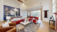 The Harrison Landing Clubhouse in Perrysburg, Ohio is a single-floor community facility offering a generously sized, well-appointed space designed to serve and impress. The grand entrance foyer sets an immediate tone of elegance, featuring soaring ceilings, powder-blue wainscoting with intricate white panel molding, a dramatic checkered marble floor, and a central round marble-top table adorned with fresh florals. Natural light pours through large windows, enhancing the airy, refined atmosphere. Beyond the entrance, a sophisticated reception area greets visitors with a bold navy coffered ceiling, warm hardwood flooring, a stylish front desk, and curated gallery wall art. The expansive great room offers a welcoming social environment complete with a decorative fireplace, wall-mounted television, abundant natural light from oversized windows, and comfortable seating arrangements. A dedicated exercise room is fully equipped with cardio machines, strength training equipment, stability accessories, and vaulted ceilings that amplify the open feel of the space. Multiple private offices provide functional workspaces, one featuring plush blue carpeting and tasteful décor. Connecting hallways and closets ensure smooth circulation throughout. The clubhouse blends classical architectural details with vibrant, eclectic interior design for a distinctive and inviting community gathering place.