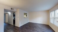 Located at 174 N Mount Tabor Rd in Lexington, Kentucky, this single-floor residence offers a well-organized layout designed for comfortable everyday living. The open living area is finished with rich, dark hardwood-style flooring and neutral walls that create a clean, versatile backdrop. A pass-through window connects the living space to the kitchen, promoting an open feel while maintaining defined zones. The kitchen is equipped with dark cabinetry, granite-style countertops, and black appliances including a refrigerator and dishwasher, all set on matching dark hardwood-style flooring. A separate dining area features the same flooring, a pendant light fixture, and a large sliding glass door dressed with vertical blinds, allowing ample natural light and potential outdoor access. The bedrooms are carpeted for comfort and each includes a closet with built-in shelving and rods for organized storage. Windows fitted with blinds bring in natural light throughout. The bathroom is appointed with a full tub and shower combo, a dark vanity with granite-style countertop, and coordinating hardwood-style flooring, completing the cohesive design aesthetic found throughout the unit.
