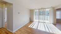 Located at 4212 E Capital Street in Washington, DC, this single-floor unit offers a well-organized layout designed for comfortable everyday living. Warm hardwood flooring runs consistently throughout the space, creating a cohesive and inviting aesthetic from room to room.

The entry hallway provides a clean, welcoming introduction to the unit, with a louvered closet for convenient storage just off the front door. The living area is bright and open, benefiting from abundant natural light streaming through large floor-to-ceiling windows fitted with vertical blinds, offering views to the outdoors. A thermostat is conveniently positioned on the wall, and the generous proportions of the room allow for flexible furniture arrangements.

A second well-proportioned room features a window with horizontal blinds that filters in natural light, making it suitable as a bedroom or home office. A dedicated walk-in closet with built-in shelving and overhead lighting provides ample storage.

The kitchen is equipped with warm wood cabinetry, light countertops, and a black gas range with a built-in overhead ventilation hood — a practical setup for home cooking.

The bathroom features classic white subway tile wainscoting, a wood-vanity with a mirrored medicine cabinet, chrome fixtures, and white mosaic tile flooring, presenting a clean and functional design. Throughout the unit, neutral wall tones and consistent finishes contribute to a bright, move-in-ready atmosphere.