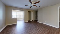 Located at 1 Saint George Blvd, Unit 210 in Savannah, GA, this single-floor residence offers a well-organized layout with a comfortable mix of living, sleeping, and utility spaces. The open-concept living and dining area is finished with durable wood-style laminate flooring and features a ceiling fan with light fixture, providing both air circulation and ambient lighting. Large windows along one wall allow natural light to fill the space, creating a bright and welcoming atmosphere. A closet and additional storage are conveniently accessible from the main living area.

The galley-style kitchen is efficiently designed with white cabinetry, granite-patterned countertops, a stainless steel sink, and white appliances including a refrigerator, electric range, and over-the-range microwave. Stone-tile flooring completes the kitchen's clean, functional aesthetic.

The bedrooms are carpeted for comfort, each featuring neutral wall tones, standard windows with blinds for natural light and privacy, and easy access to the bathrooms. The bathrooms are well-appointed with granite-style countertops, white vanity cabinetry, and a tub-shower combination, reflecting a consistent and practical design throughout the unit.