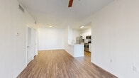 Located in Tampa, FL, this well-appointed 2-bedroom, 2-bathroom residence offers a thoughtfully designed single-floor layout with a clean, modern aesthetic throughout. The open-concept living and dining area is bright and airy, featuring wood-style flooring and a ceiling fan, and flows directly to a sliding glass door that opens onto one of two private balconies, inviting natural light and outdoor views into the space.

The galley-style kitchen is efficiently designed and equipped with stainless steel appliances, including a range, microwave, and refrigerator, complemented by crisp white cabinetry, light countertops, and a stainless steel sink. A peninsula connects the kitchen to the main living area, creating a natural gathering point.

Both bedrooms are generously proportioned, with the primary bedroom offering ample square footage, wood-style flooring, and a ceiling fan. Each room benefits from large windows with blinds that allow for controlled natural light. Three closets provide substantial storage throughout the unit.

The bathrooms are finished with white cabinetry, light countertops, tiled tub-shower combinations, and warm wood-style flooring. A dedicated laundry room houses a full-size washer and dryer with overhead shelving. Consistent wood-style flooring and neutral tones throughout lend the space a cohesive and inviting character.
