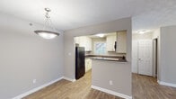 Located at 1806 Cobb Crossing SE in Smyrna, Georgia, this single-story home offers a thoughtfully arranged layout with a neutral color palette of soft gray tones throughout. The living area is generously sized, featuring wood-look flooring, a ceiling fan with light fixture, and a wall of windows paired with a sliding glass door that provides abundant natural light and direct access to an outdoor space. The open flow continues into a connected dining area, illuminated by a pendant light fixture.

The kitchen is well-appointed with white cabinetry, dark granite-style countertops, a mosaic tile backsplash, and a suite of black appliances including a gas range, built-in microwave, dishwasher, and refrigerator. A pass-through opening connects the kitchen to the dining area, enhancing the open feel.

The bedrooms are carpeted and each equipped with a ceiling fan. Multiple bedrooms include closet storage, with at least one featuring an organized closet system. The bathroom includes a full tub-shower combination with white tile surround and chrome fixtures. The home's textured ceilings are consistent throughout, adding a classic architectural element.