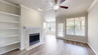 Located at 3075 Bellaire Ranch Drive in Fort Worth, TX, this single-story, 3-bedroom, 2-bathroom home offers a well-designed layout with a comfortable and functional living experience. The open living and dining area serves as the heart of the home, featuring wood-look flooring, crown molding, a ceiling fan, and a tile-surround fireplace flanked by built-in shelving — an ideal spot for both relaxing and entertaining. Large windows invite abundant natural light throughout, with a glass door providing direct outdoor access. The kitchen is well-appointed with rich dark wood cabinetry, granite countertops, a white subway tile backsplash, and stainless steel appliances, including a range and over-the-range microwave. A pass-through connects the kitchen to the living area, enhancing the open feel. The spacious primary bedroom features plush carpet, crown molding, and a walk-in closet with wire shelving. Additional bedrooms are similarly finished with carpet and crown molding. The bathrooms include granite-topped vanities, dark wood cabinetry, and a tub-shower combination with white tile surround. A dedicated laundry room with full-size washer and dryer hookups completes this thoughtfully laid-out home.