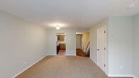 Located at 1282 Daly Dr in New Haven, Indiana, this two-story home offers a practical and well-organized layout across two equally proportioned floors. The main level features a carpeted living room with soft neutral tones, opening to a dedicated kitchen and a hallway leading to a staircase. The kitchen is equipped with medium-toned shaker-style cabinetry, light stone-look countertops, a stainless steel sink and dishwasher, and a black electric range. A sliding glass door on the main level allows natural light to filter in while offering views of the backyard and fenced outdoor area. Upstairs, two carpeted bedrooms provide comfortable accommodations. The primary bedroom includes a ceiling fan, a window with natural light, and a sliding-door closet. The second bedroom is bright and open with easy hallway access. Both floors are served by their own bathrooms. The bathrooms feature warm wood-toned vanities with stone-look countertops and brushed nickel fixtures, with one bathroom offering a glass-door shower and wood-look flooring. Soft, neutral paint tones are carried throughout the home, creating a clean and cohesive ambiance. Each bedroom includes a dedicated closet, and hallways on both floors ensure efficient circulation throughout the space.