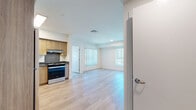 Located at 1642 E Florence Ave in Los Angeles, CA, this two-bedroom unit offers a thoughtfully designed single-floor layout that maximizes functionality and comfort. Light wood laminate flooring runs seamlessly throughout the entire space, creating a warm and cohesive aesthetic.

The combined kitchen and living area serves as the heart of the home. The kitchen is outfitted with stainless steel appliances—including a refrigerator, range, and dishwasher—complemented by warm wood cabinetry, dark countertops, and a skylight that draws in abundant natural light. Ample cabinet storage extends to the ceiling, optimizing every inch of the space.

The living area is bright and open, with large windows dressed in vertical blinds that invite natural light while offering views of the surrounding neighborhood. Both bedrooms maintain the clean, minimal aesthetic of the rest of the unit, featuring white walls, sliding closet doors, and windows that provide outdoor views and natural light. The primary bedroom offers a comfortable footprint well-suited for a full bedroom setup.

Throughout the unit, the design emphasizes clean lines, neutral tones, and practical finishes, creating a bright and move-in-ready environment in the heart of Los Angeles.