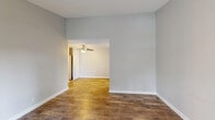 This single-floor, 2-bedroom, 1-bathroom residence offers a practical and comfortable layout designed to maximize functionality. The living room is a welcoming, open space featuring rich wood-style flooring, soft gray walls, a textured ceiling, and a ceiling fan. A sliding glass door floods the room with natural light and provides direct outdoor access, while a front entry door adds convenience. The open-style layout connects the living area seamlessly to the rest of the home. The kitchen is efficiently designed with white cabinetry, light wood-style flooring, a skylight panel for added brightness, and a full suite of stainless steel appliances including a refrigerator, dishwasher, and range. The primary bedroom offers a comfortable footprint with plush carpeting, neutral gray walls, a textured ceiling, and a window with outdoor views. The second bedroom also features soft carpeting and a clean, neutral palette. A dedicated walk-in closet with dual hanging rods and carpeted flooring provides ample storage. The full bathroom is finished in a crisp white palette with wood-style flooring, a vanity with updated cabinetry, and a tub-shower combination. Throughout, the consistent use of neutral tones and updated finishes lends a clean, move-in-ready aesthetic to the entire home.