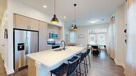 Located at 550 Great Circle Road in Nashville, TN, this well-appointed 2-bedroom, 2-bathroom residence combines modern design with functional living across a single floor. The open-concept layout seamlessly connects the kitchen, dining area, and living room, creating a bright and cohesive central space. The kitchen is a standout feature, outfitted with light wood cabinetry, stainless steel appliances, a subway tile backsplash, and a generous island with a white quartz countertop, undermount sink, and pendant lighting — ideal for both cooking and casual dining. The adjacent dining area is bathed in natural light from large windows dressed with sheer curtains, offering a welcoming atmosphere. Rich wood-tone flooring runs throughout the space, complementing the clean white walls and black hardware accents. Both bedrooms are comfortably sized, with natural light from well-positioned windows. The primary bedroom includes its own bathroom featuring a light wood vanity, quartz countertop, glass-enclosed shower, and matte black fixtures. The second bathroom is equally refined in style. Additional highlights include multiple closets, a dedicated laundry area, a utility room, a hallway with a slatted accent wall detail, an entrance, and a private balcony.