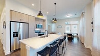 Located at 550 Great Circle Road in Nashville, TN, this well-appointed 2-bedroom, 2-bathroom residence combines modern design with functional living across a single floor. The open-concept layout seamlessly connects the kitchen, dining area, and living room, creating a bright and cohesive central space. The kitchen is a standout feature, outfitted with light wood cabinetry, stainless steel appliances, a subway tile backsplash, and a generous island with a white quartz countertop, undermount sink, and pendant lighting — ideal for both cooking and casual dining. The adjacent dining area is bathed in natural light from large windows dressed with sheer curtains, offering a welcoming atmosphere. Rich wood-tone flooring runs throughout the space, complementing the clean white walls and black hardware accents. Both bedrooms are comfortably sized, with natural light from well-positioned windows. The primary bedroom includes its own bathroom featuring a light wood vanity, quartz countertop, glass-enclosed shower, and matte black fixtures. The second bathroom is equally refined in style. Additional highlights include multiple closets, a dedicated laundry area, a utility room, a hallway with a slatted accent wall detail, an entrance, and a private balcony.