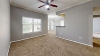 Located in Cypress, TX, this single-story, 2-bedroom, 1-bathroom home offers a functional and comfortable layout designed for easy everyday living. The interior is finished with neutral gray walls and plush carpeting throughout the living and bedroom areas, creating a cohesive and inviting atmosphere.

The open living area features crown molding, a ceiling fan with light fixture, and multiple windows fitted with blinds that allow ample natural light to fill the space. A pass-through counter connects to the kitchen area, enhancing the open feel of the main living zone.

The primary bedroom is generously sized, boasting vaulted ceilings, a ceiling fan, and a sliding glass door with vertical blinds that opens to an outdoor view, bringing in abundant natural light. The second bedroom also features carpeted floors, a ceiling fan, and a built-in closet with bifold doors for convenient storage.

The bathroom is clean and well-equipped, featuring a combined shower and soaking tub with tiled surround, wood-look flooring, and modern brushed nickel fixtures. A hallway connects the rooms efficiently, and a dedicated closet provides additional storage throughout the home. Ceiling fans are present in multiple rooms, ensuring year-round comfort throughout this practical and neatly maintained home.