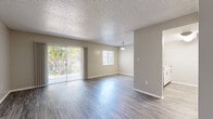 Located at 321 Imperial Blvd in Lakeland, Florida, this single-story, 2-bedroom, 1-bathroom home offers a practical and well-appointed layout. The combined kitchen and living area serves as the heart of the home. The living room features durable wood-look flooring, neutral-toned walls, a textured ceiling, and a pendant light fixture. A full-length sliding glass door, dressed with vertical blinds, opens to lush outdoor greenery and is complemented by an additional window that fills the space with natural light. The kitchen is outfitted with white shaker-style cabinetry, granite-look countertops, wood-look tile flooring, a double basin sink, a dishwasher, and a full-size refrigerator, providing ample functionality. Both bedrooms feature plush carpeting and ceiling fans. The primary bedroom is generously sized, offering a wide window for natural light and a double sliding-door closet with built-in shelving. The second bedroom also includes a ceiling fan and its own closet access. The full bathroom is cleanly finished with a white vanity, a tiled tub-shower combination, and wood-look flooring. A hallway connects the living spaces, completing the efficient and cohesive floor plan.