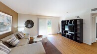 Located at Ravens Crest Drive in Plainsboro, NJ, this single-floor, 2-bedroom, 2-bathroom residence offers a thoughtfully designed open-concept layout. The living area features warm hardwood flooring, a sliding glass door that opens to a private outdoor patio, and ample natural light. A bold accent wall adds depth to the space, which flows seamlessly into the dining area.

The kitchen is well-equipped with warm-toned wood cabinetry, granite countertops, stainless steel appliances including a refrigerator and range, track lighting, and a peninsula with pendant lighting that connects to the main living space.

The primary bedroom features plush carpeting, multiple windows with natural light, and neutral tones creating a restful atmosphere. The second bedroom is similarly carpeted and bright, with generous wall space. Both bedrooms are served by their own full bathrooms, each featuring a tub-shower combination, white vanity with sink, and hardwood-style flooring.

The overall ambiance is clean, neutral, and functional, providing a comfortable and practical living environment suitable for a range of lifestyles.