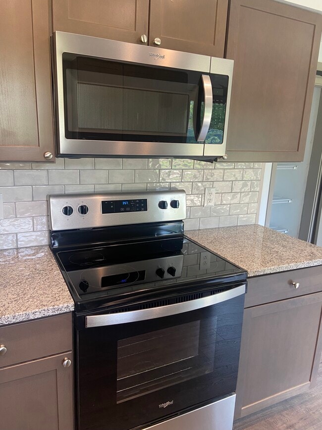 Remodeled Kitchen with granite counters, tile backsplash, and new appliances - 174 Brisbane Ave