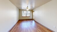 Located at 1040 NW 10th Ave in Portland, Oregon, this one-bedroom, one-bathroom residence offers a well-organized, efficiently designed floor plan. Warm hardwood-style flooring runs throughout the unit, lending a cohesive and inviting feel to every room.

The entrance opens into a hallway that connects the main living spaces. The combined living and dining area is the heart of the unit, featuring a ceiling fan with light fixture, neutral-toned walls, and large windows that invite natural light. A door from this area provides direct access to a private balcony, ideal for outdoor relaxation.

The kitchen is appointed with light maple cabinetry, dark countertops, a stainless steel sink, a full-size refrigerator, and a range with overhead ventilation, offering ample storage and functionality.

The bedroom is a comfortable, well-proportioned space with its own ceiling fan, a large window with views of the surrounding neighborhood, and a baseboard heater. Two closets provide generous storage throughout the unit.

The bathroom features hardwood-style flooring, a combination tub and shower, a vanity with dark countertops and light wood cabinetry, and accessible grab bars, reflecting a thoughtful and practical design. The overall aesthetic of the unit is clean, functional, and well-suited for urban living in Portland's vibrant Northwest district.