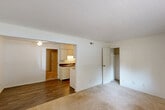 Located at 1151 Roger Ave in Swansea, IL, this one-bedroom, one-bathroom unit offers a practical and efficiently designed single-floor layout. The living area is carpeted and open, connecting seamlessly to the kitchen, which features white cabinetry, a dark countertop, a sink, and wood-look flooring that extends through the functional spaces. A ceiling fan with a light fixture is present in the living area, providing both airflow and overhead lighting. The bedroom is a well-proportioned, carpeted room equipped with its own ceiling fan and a window that allows natural light to filter in, offering a view of the surrounding greenery. A dedicated closet with shelving is accessible directly from the bedroom, providing organized storage space. A second closet is also available off the main living area for additional storage. The full bathroom includes a tub-shower combination with white surround, a toilet, a single vanity with white cabinetry, and wood-look flooring, maintaining a clean and functional aesthetic throughout. The unit's neutral white walls and light-toned carpeting create a bright, move-in-ready environment suited for comfortable everyday living.