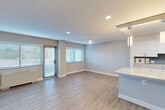 Located at 8201 16th St NW in Silver Spring, MD, this well-designed 2-bedroom, 2-bathroom residence offers a thoughtfully laid-out single-floor plan with a clean, modern aesthetic throughout. The open-concept kitchen and living area serves as the heart of the home, featuring light hardwood-style flooring, recessed lighting, and a ceiling fan. The kitchen is appointed with crisp white cabinetry, granite countertops, a tile backsplash, stainless steel sink, and a central island with pendant lighting — all flowing seamlessly into the spacious living area. Sliding glass door access leads to a private balcony, while multiple windows fitted with blinds allow for generous natural light. The generous primary bedroom features plush carpeting, a ceiling fan, and access to a large walk-in closet with dual hanging rods. The second bedroom is equally well-sized with carpeting and its own closet. Both bathrooms are finished with granite-topped vanities and clean white cabinetry; one includes a tiled shower with decorative diamond-pattern accents, while the other offers a glass-enclosed shower stall. Five total closets provide exceptional storage throughout. The neutral gray palette and consistent finishes lend the entire residence a cohesive, contemporary feel.