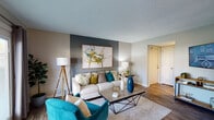 Located in Louisville, KY (40245), this single-floor residence offers a thoughtfully designed open-concept layout that seamlessly connects its living, dining, and kitchen areas. The living room is a standout space, anchored by a bold accent wall in deep gray and French doors that allow abundant natural light while providing outdoor access. Wood-style flooring runs throughout the main living areas, adding warmth and continuity to the design.

The kitchen is well-equipped with white cabinetry, granite countertops, stainless steel appliances including a refrigerator, electric range, and microwave, and a peninsula that doubles as a breakfast bar. Adjacent to the kitchen, the dining area offers an intimate setting with direct sightlines to the living space.

The bedrooms are generously proportioned, each featuring natural light from windows with blinds and curtains, soft carpeted floors, and closet storage. The neutral gray tones throughout create a calm, cohesive atmosphere.

The bathroom features a tub and shower combination with large-format marble-style tile surround, granite countertops at the vanity, and wood-style flooring. Overall, the residence presents a modern, coordinated aesthetic with consistent finishes and a comfortable, functional floor plan.