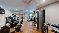 Located at 10810 Rail Way in Lone Tree, CO, this fitness center is a well-appointed, single-room exercise facility designed to support a comprehensive workout routine. The space features warm hardwood flooring throughout, neutral gray walls, and recessed lighting that creates a clean, energizing atmosphere.

The room is outfitted with a variety of Spirit-brand cardio equipment, including treadmills, elliptical trainers, and both upright and recumbent stationary bikes, catering to a range of fitness preferences. Strength training is supported by a multi-function cable machine and a dedicated leg extension/curl station, providing options for both upper and lower body conditioning. A wall-mounted flat-screen television adds an entertainment element for users during workouts.

A full wall of mirrors along one side of the room visually expands the space and allows users to monitor their form during exercise. The layout is thoughtfully organized to maximize usable floor area while maintaining comfortable movement between stations. HVAC vents are integrated into the ceiling, ensuring proper climate control. A dedicated entry door with a windowed panel provides access to the facility. The overall design is functional, modern, and well-maintained, making it a practical fitness resource for residents of the Lone Tree community.