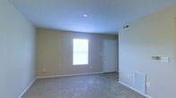 Located at 2591 Venturi House in Columbus, Ohio, this single-floor residence offers a straightforward and functional layout designed for comfortable everyday living. The main living area is finished with wall-to-wall carpeting in a neutral tone, creating a warm and approachable atmosphere throughout the space. Smooth, light-colored walls complement the overall clean aesthetic, while recessed ceiling lighting provides consistent illumination. A window in the living area allows natural light to filter in, brightening the interior and adding a sense of openness. A dedicated entryway door provides direct access to the living space, contributing to the home's practical flow. Ventilation registers are positioned thoughtfully throughout, supporting efficient climate control. The neutral color palette of beige walls and light carpet tones creates a versatile backdrop well-suited for a variety of interior styles. Overall, this single-story home presents a tidy, move-in ready environment with a simple, uncluttered design ideal for those seeking a low-maintenance living space in the Columbus, Ohio area.