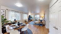 This well-appointed 4-bedroom, 2-bathroom unit in Seattle, WA offers a thoughtfully designed single-floor layout that maximizes comfort and functionality. The open-concept living and dining area is anchored by warm hardwood-style flooring, large windows that flood the space with natural light, and a stylish fireplace with a granite surround — a striking focal point of the room. Sliding glass doors lead to an outdoor balcony, extending the living space and offering pleasant exterior views.

The kitchen features light wood cabinetry, dark granite countertops, stainless steel appliances, and a peninsula with pendant lighting that connects seamlessly to the dining area — ideal for both everyday living and entertaining. Tile flooring adds a practical touch to this functional cooking space.

The primary bedroom is a comfortable retreat, highlighted by large windows with wooded views and plush carpeting. Additional bedrooms are well-sized and bright, each with windows that invite natural light. The bathrooms are clean and functional, featuring a tub-shower combination. Two hallways and a dedicated closet provide ample storage and easy circulation throughout the home. The overall ambiance is light, modern, and welcoming.