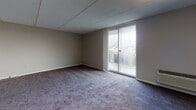 Located at 402 Foulk Rd in Wilmington, Delaware, this single-floor unit offers a practical and straightforward layout designed for comfortable everyday living. The expansive living area is carpeted in a neutral tone and bathed in natural light through a large sliding glass door that opens to a balcony, providing outdoor views of the surrounding neighborhood. A wall-mounted HVAC unit ensures climate control convenience directly within the living space.

The layout flows from the living area into a separate bedroom, also carpeted and generously sized, featuring its own window with natural light and a wall-mounted HVAC unit. The bedroom connects to a closet and provides easy access to the rest of the unit.

The kitchen is efficiently designed with white cabinetry offering ample storage, light countertops, a stainless steel sink, and a white electric range with an overhead exhaust hood. The kitchen flooring contrasts with the carpeted rooms, adding functional distinction to the space.

The bathroom features wood-look vinyl flooring, white tile wainscoting, and clean, simple fixtures. Throughout the unit, neutral-toned walls, white trim, and consistent finishes create a cohesive and understated aesthetic suited to a variety of personal styles.