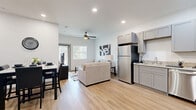 Located at 4100 Preferred Place in Dallas, TX, this one-bedroom, one-bathroom residence offers a thoughtfully designed open-concept floor plan that maximizes every inch of its comfortable footprint. Light wood-style flooring runs continuously throughout, lending warmth and visual cohesion to the entire space.

The combined living, dining, and kitchen area serves as the heart of the home. The kitchen is equipped with a full suite of stainless steel appliances—including a refrigerator, range with over-the-range microwave, and dishwasher—complemented by gray shaker-style cabinetry, granite-look countertops, and a tile backsplash. Ample cabinet storage extends to the ceiling for maximum utility. The adjacent living area benefits from large windows and a sliding glass door that invite natural light and provide outdoor views, while a ceiling fan adds comfort overhead.

The bedroom is a calm, well-lit retreat featuring a ceiling fan, a closet with paneled doors, and a window overlooking greenery. Three closets total offer generous storage throughout the unit. The bathroom includes a full soaking tub and shower combo with large-format tile surrounds and brushed nickel fixtures. A dedicated laundry area rounds out the practical amenities of this efficiently designed Dallas residence.