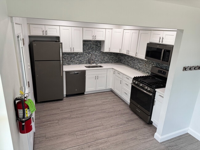 Kitchen with quartz counter tops, gas range, refrigerator/freezer, microwave, and dishwasher - 251 Main St