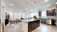 This thoughtfully designed one-bedroom, one-bathroom residence in Waco, Texas delivers a modern living experience within an efficiently organized single-floor layout. The open-concept kitchen, dining, and living area serves as the heart of the home, featuring rich dark cabinetry, stainless steel appliances, and a generous granite-topped island with pendant lighting overhead — ideal for both meal prep and casual dining. Light wood-style flooring flows throughout the main living spaces, complementing the bright, airy atmosphere created by multiple large windows dressed with white blinds and sheer curtains. The dining area benefits from direct access to natural light via a full glass door, creating a welcoming space for entertaining. The living area offers recessed lighting and ample room for comfortable furnishings. The bedroom is carpeted for warmth and comfort, featuring tall ceilings and a calm, neutral palette. The well-appointed bathroom includes a granite vanity with dark cabinetry, a glass-enclosed shower, and direct access to a walk-in closet outfitted with built-in shelving and hanging rods for organized storage. A dedicated hallway connects the spaces efficiently, completing this polished and functional Waco residence.