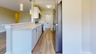 Located at 1134 Adelaide St N in London, Ontario, this 2-bedroom, 1-bathroom unit offers a thoughtfully designed layout across a single floor. The space features consistent light wood-tone laminate flooring throughout, complemented by neutral warm-toned walls that create a bright and welcoming atmosphere.

The kitchen is sleek and functional, outfitted with crisp white cabinetry, light quartz countertops, stainless steel appliances including a refrigerator, stove, and over-the-range microwave, and stylish pendant lighting. It connects seamlessly to the dining area via a pass-through counter, enhancing the open feel.

The living room is generously sized and filled with natural light from a large sliding glass door that leads to a private balcony overlooking mature trees, bringing a sense of greenery and tranquility indoors.

Both bedrooms are well-proportioned and include sliding-door closets for ample storage. The primary bedroom offers a comfortable footprint, with a window framing pleasant outdoor views. The bathroom features a full soaker tub with clean white subway tile surround and chrome fixtures.

Completing the unit are four closets and a dedicated entrance, providing excellent storage and practicality throughout. The overall design is modern, clean, and move-in ready.