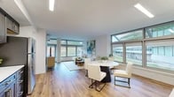 This well-appointed 2-bedroom, 2-bathroom residence at 100 Reserve Road in Danbury, CT offers a thoughtfully designed single-floor layout filled with natural light and contemporary finishes. The open-concept living and dining area is anchored by expansive floor-to-ceiling windows that frame sweeping views of the surrounding wooded landscape, creating a bright and airy atmosphere. Warm hardwood flooring flows seamlessly throughout the entire space, tying the rooms together cohesively.

The kitchen is a standout feature, showcasing rich dark cabinetry, white quartz countertops, a classic subway tile backsplash, and a full suite of stainless steel appliances, including a range, microwave, dishwasher, and refrigerator. Ample cabinet storage and counter space make this a highly functional cooking area.

The primary bedroom is generously sized and benefits from a dramatic wall of windows overlooking lush greenery, offering a serene, nature-filled retreat. The second bedroom is equally comfortable and well-lit. Both bathrooms are clean and modern, featuring white cabinetry, stone-toned countertops, and hardwood flooring, with one offering a walk-in shower and the other a full tub-shower combination. Two hallways and a dedicated closet provide practical storage and connectivity throughout this refined, light-filled home.