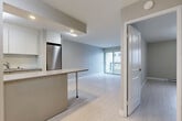 Located at 1436 MacKay in the heart of Montréal, this one-bedroom, one-bathroom unit offers a thoughtfully organized layout across a single floor. The open-concept living and kitchen area serves as the central hub of the space, with light hardwood-style flooring flowing throughout and a neutral grey-toned palette that creates a bright, contemporary atmosphere. The kitchen features white cabinetry, a stainless steel refrigerator, a central island with a sleek countertop, and light tile flooring — ideal for both everyday use and casual dining. The living area is well-proportioned, receiving natural light through a sliding glass door that opens directly onto a private balcony with city views. The spacious bedroom offers a window with an urban Montréal skyline outlook, light flooring, and a baseboard heating unit. Three closets distributed throughout the unit provide generous storage. The bathroom is finished with full white tile, a soaker tub with shower, and a clean modern vanity. A hallway connects the main rooms efficiently, and the unit also includes an unclassified bonus room that offers added flexibility. Overall, the space presents a clean, move-in-ready environment with a modern, minimalist finish throughout.