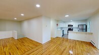 Located at 404 Blue Spring Rd in Princeton, NJ, this single-floor residence offers a clean, modern aesthetic defined by warm hardwood flooring and a crisp white interior throughout. The open-plan living and kitchen area forms the heart of the home, where gleaming hardwood floors reflect recessed lighting and create an inviting, airy atmosphere. The kitchen is well-appointed with white shaker-style cabinetry, a full suite of stainless steel appliances including a refrigerator, range, microwave, and dishwasher, as well as a peninsula with a white countertop that serves as a casual dining or workspace. A matte black sink fixture adds a contemporary accent.

The bedrooms are generously proportioned, featuring the same warm hardwood floors, baseboard heating, and windows fitted with blinds that allow natural light to filter in while framing views of the surrounding greenery. One bedroom includes a built-in closet with shelving and hanging rods for practical storage.

The bathroom is finished with light tile work surrounding a full soaking tub and shower combination, complemented by a white vanity, tile flooring, and a wall-mounted mirror. The overall ambiance is clean, bright, and understated, set within a lush, wooded environment that enhances the sense of quiet and privacy.