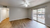 Located at 1400 Cherokee Rd in Florence, South Carolina, this well-appointed one-bedroom, two-bathroom unit offers a comfortable and functional layout across a single floor. Wood-look flooring flows consistently throughout the space, complemented by neutral gray walls and textured ceilings that lend a clean, cohesive aesthetic.

The combined kitchen and living area forms the heart of the unit. The galley-style kitchen is outfitted with white cabinetry, dark countertops, and black appliances including a refrigerator, electric range, and dishwasher. Adjacent to the kitchen, the open living area features a ceiling fan and is brightened by a sliding glass door that leads to a private balcony, offering outdoor views.

The spacious primary bedroom provides a generous retreat, featuring a ceiling fan, a large window for natural light, and two closets — including a wide louvered double-door closet for ample storage. The hallway connects the bedroom to both bathrooms. The primary bathroom includes a white vanity with cabinet storage, a lighted mirror, and wood-look tile flooring. The second bathroom features a full tub-shower combo with built-in shelving.

A dedicated hallway with additional closet space enhances the unit's practical storage options, making this a thoughtfully designed and move-in ready home.