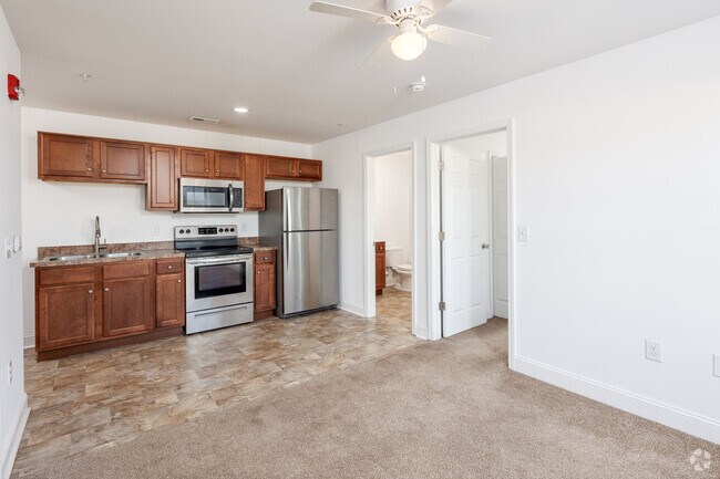 Carpeted living room towards kitchen. - 1200 Hemingway Chapel Rd