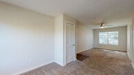 This single-floor unit offers a practical and efficiently designed layout across two bedrooms, one bathroom, a kitchen, and a closet. The overall floor plan flows logically from the entryway, which features wood-look hard flooring that transitions into plush carpeting throughout the living and sleeping areas.

The primary bedroom is notably spacious for the unit's overall footprint, accommodating a ceiling fan and a window fitted with blinds that allow natural light to filter in. The second bedroom mirrors a similar design with carpeted flooring, neutral beige walls, and a window providing natural light and outdoor views.

The kitchen is well-appointed with white shaker-style cabinetry, granite-look countertops, a subway tile backsplash, and wood-look plank flooring. White appliances, including a refrigerator, electric range, and over-the-range microwave, complete the space.

The bathroom features a full tub-shower combination with floor-to-ceiling white subway tile, a granite-topped vanity with white cabinetry, and wood-look flooring. The unit also includes a dedicated closet for additional storage. Neutral wall tones throughout contribute to a clean, cohesive aesthetic.