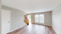 Located at 5298 Salem Woods Dr in Trotwood, Ohio, this two-story home offers a well-organized layout distributed equally across both floors. The main level features a welcoming entrance that opens into a bright, open living room finished with light wood-style laminate flooring and neutral gray walls. A front-facing window allows natural light to filter in, offering views of the surrounding neighborhood. A warm-toned wood staircase with a classic baluster railing connects the two floors. The kitchen is equipped with rich medium-toned cabinetry, light marble-style countertops, a double sink, and stainless steel and black appliances, including a refrigerator, dishwasher, and range. A window above the sink provides additional natural light. A half bath on the main level features a white vanity with a mirrored medicine cabinet. Upstairs, the carpeted bedrooms offer a comfortable, quiet retreat. The primary bedroom is a generously sized room with a closet and a window overlooking the exterior. The second bedroom is similarly finished with neutral carpet and easy hallway access. A full bathroom upstairs includes a tub-shower combination unit. A hallway and closet complete the upper level.