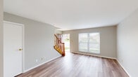 Located at 5298 Salem Woods Dr in Trotwood, Ohio, this two-story home offers a well-organized layout distributed equally across both floors. The main level features a welcoming entrance that opens into a bright, open living room finished with light wood-style laminate flooring and neutral gray walls. A front-facing window allows natural light to filter in, offering views of the surrounding neighborhood. A warm-toned wood staircase with a classic baluster railing connects the two floors. The kitchen is equipped with rich medium-toned cabinetry, light marble-style countertops, a double sink, and stainless steel and black appliances, including a refrigerator, dishwasher, and range. A window above the sink provides additional natural light. A half bath on the main level features a white vanity with a mirrored medicine cabinet. Upstairs, the carpeted bedrooms offer a comfortable, quiet retreat. The primary bedroom is a generously sized room with a closet and a window overlooking the exterior. The second bedroom is similarly finished with neutral carpet and easy hallway access. A full bathroom upstairs includes a tub-shower combination unit. A hallway and closet complete the upper level.