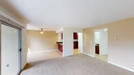 Located at 50 Washington St in Santa Clara, California, this single-floor unit offers a well-designed, functional layout with a comfortable, neutral aesthetic throughout. The spacious living area features soft carpeting, warm beige walls, and a ceiling fan, with generous natural light streaming in through a large sliding glass door that opens to a private patio overlooking lush greenery. A separate window further brightens the adjoining space, creating an airy, connected feel.

The kitchen is a standout feature, showcasing rich dark cherry wood cabinetry, dark granite countertops, and a bold red peninsula with a stainless steel sink — an eye-catching focal point that anchors the open layout. White appliances, including a range, microwave, dishwasher, and refrigerator, are set against recessed lighting, lending the kitchen a clean, practical character. Light wood-style flooring runs through the kitchen and entry areas.

The bedrooms are carpeted and well-proportioned, each with windows that admit natural light. Closet storage is provided, and baseboard heating ensures comfort year-round. Both bathrooms feature dark granite countertops, rich wood vanities, and light tile flooring. The full bath includes a tub-shower combination with sliding glass doors, while the second bath offers a single vanity with a large mirror.