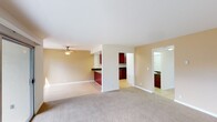 Located at 50 Washington St in Santa Clara, California, this single-floor unit offers a well-designed, functional layout with a comfortable, neutral aesthetic throughout. The spacious living area features soft carpeting, warm beige walls, and a ceiling fan, with generous natural light streaming in through a large sliding glass door that opens to a private patio overlooking lush greenery. A separate window further brightens the adjoining space, creating an airy, connected feel.

The kitchen is a standout feature, showcasing rich dark cherry wood cabinetry, dark granite countertops, and a bold red peninsula with a stainless steel sink — an eye-catching focal point that anchors the open layout. White appliances, including a range, microwave, dishwasher, and refrigerator, are set against recessed lighting, lending the kitchen a clean, practical character. Light wood-style flooring runs through the kitchen and entry areas.

The bedrooms are carpeted and well-proportioned, each with windows that admit natural light. Closet storage is provided, and baseboard heating ensures comfort year-round. Both bathrooms feature dark granite countertops, rich wood vanities, and light tile flooring. The full bath includes a tub-shower combination with sliding glass doors, while the second bath offers a single vanity with a large mirror.