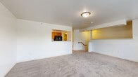 Located at 721 S Mountain Rd in Dillsburg, PA, this three-bedroom, two-bathroom home offers a practical and well-organized layout. The combined kitchen and living area serves as the heart of the home, with the open-plan living room featuring plush wall-to-wall carpeting and a pass-through window connecting to the kitchen. The galley-style kitchen is outfitted with warm oak cabinetry, ample counter space, a double sink, and black appliances including an electric range and refrigerator, all set on classic checkered tile flooring. Natural light filters in through multiple windows, enhancing the bright, neutral interior throughout. A carpeted staircase with a wood handrail leads to the upper level. The three bedrooms are carpeted and feature white walls, windows with outdoor views, and closets with built-in shelving and hanging rods. The two full bathrooms each include a tub-shower combination and vanity with oak cabinetry, set on durable stone-look tile flooring. Grab bars in the bathrooms add an accessible touch. The hallway connects the bedrooms and bathrooms efficiently, completing a straightforward and functional floor plan suited for comfortable everyday living.