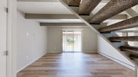 Located at 250 Grand Circuit Blvd in Delaware, Ohio, this two-story, one-bedroom, one-bathroom unit offers a practical and well-organized layout spread across two evenly sized floors. The main level houses the open living, dining, and kitchen areas, characterized by light hardwood-style flooring and distinctive exposed wooden ceiling beams that lend a touch of architectural character. A sliding glass door on the main floor allows natural light to pour in and provides easy access to the outdoors. The lower level also includes two closets for convenient storage. Upstairs, the generously sized primary bedroom features plush carpeting and is served by a dedicated staircase with a white-railed banister. The upper floor also benefits from natural light through a window with blinds. The full bathroom is thoughtfully appointed with a tub/shower combination featuring elegant marble-look wall surround panels with brushed nickel fixtures, complemented by warm wood-tone flooring and a vanity. Throughout the unit, neutral tones on the walls create a clean and versatile backdrop. This unit offers a compact yet functional living experience ideal for those seeking a multi-level layout in a residential Delaware, Ohio community.