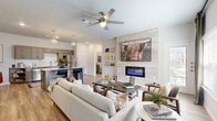 This thoughtfully designed 2-bedroom, 2-bathroom residence combines modern aesthetics with everyday functionality across a single, well-appointed floor. The open-concept living area serves as the heart of the home, anchored by a striking tile-framed linear fireplace and ceiling fan overhead. Light wood-style flooring flows throughout, creating a warm and cohesive ambiance. Large windows invite natural light, enhancing the bright, airy feel of the space.

The kitchen is a standout feature, boasting warm-toned shaker cabinetry, granite countertops, a classic subway tile backsplash, stainless steel appliances, and a central island with bar seating — all illuminated by geometric pendant lighting that adds a contemporary touch.

Both bedrooms are comfortably proportioned, with the primary bedroom offering direct access to a dedicated closet and a private en-suite bathroom. Each bathroom is well-appointed, featuring granite vanity countertops, full tub-shower combinations, and wood-style flooring. Two closets throughout the unit provide ample storage.

A dedicated in-unit laundry area with full-size washer and dryer adds a practical convenience rarely overlooked. The overall design balances clean, neutral tones with modern fixtures, making this a functional and stylish place to call home.